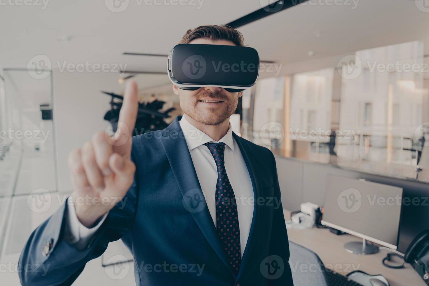 CEO man stands in office with VR headset and interacts with application virtual interface photo