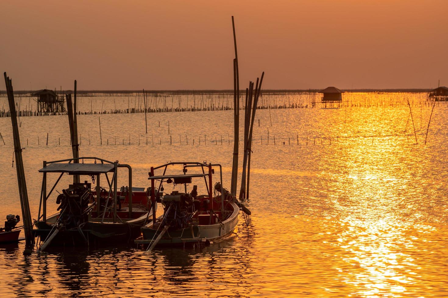 Beautiful sunset over the sea. Dark and golden sunset sky and clouds. Nature background for tranquil and peaceful concept. Sunset at Chonburi, Thailand. Art picture of sky at dusk. Farming in the sea. photo