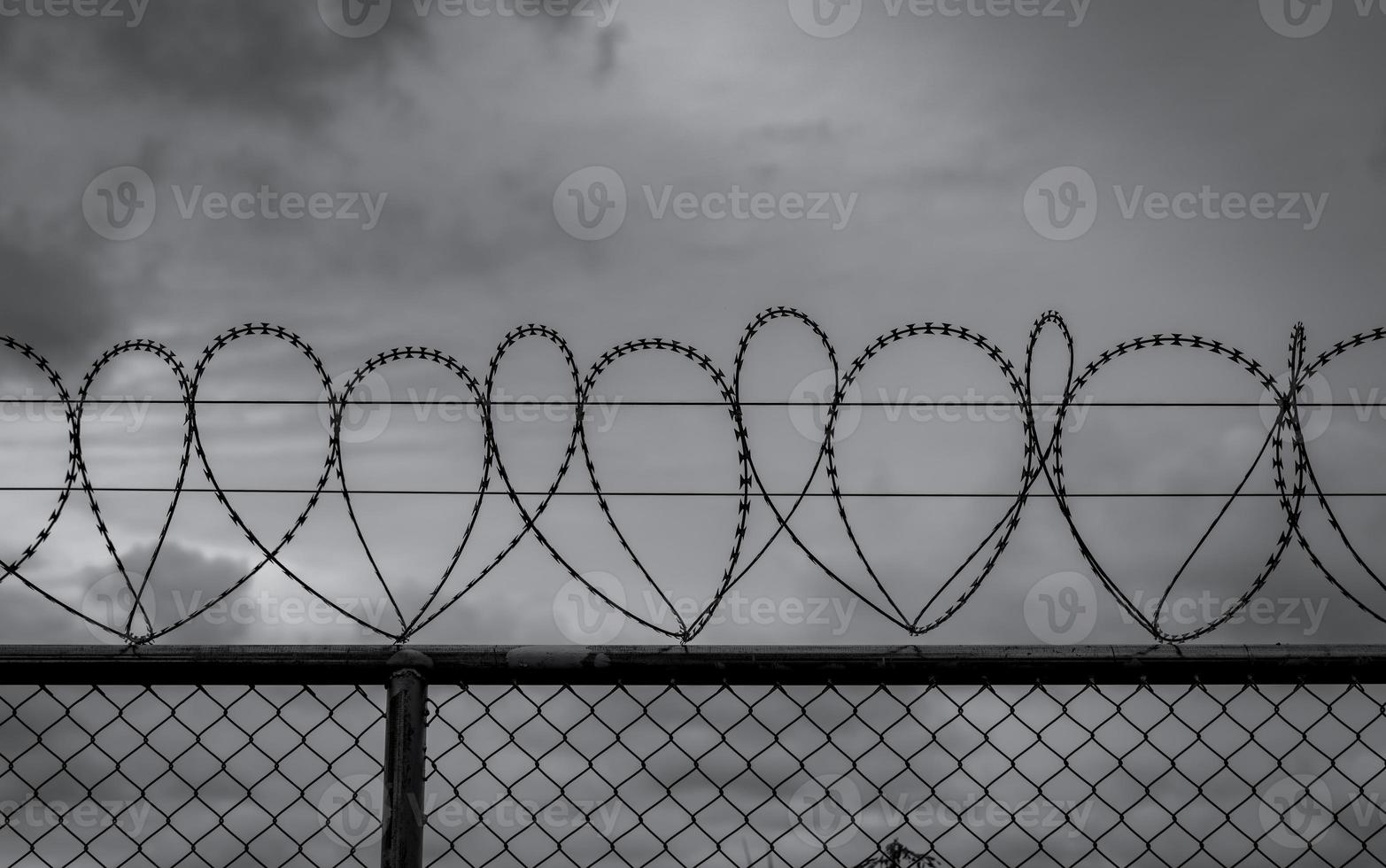 Prison security fence. Barbed wire security fence. Razor wire jail fence. Barrier border. Boundary security wall. Prison for arrest criminals or terrorists. Private area. Military zone concept. photo