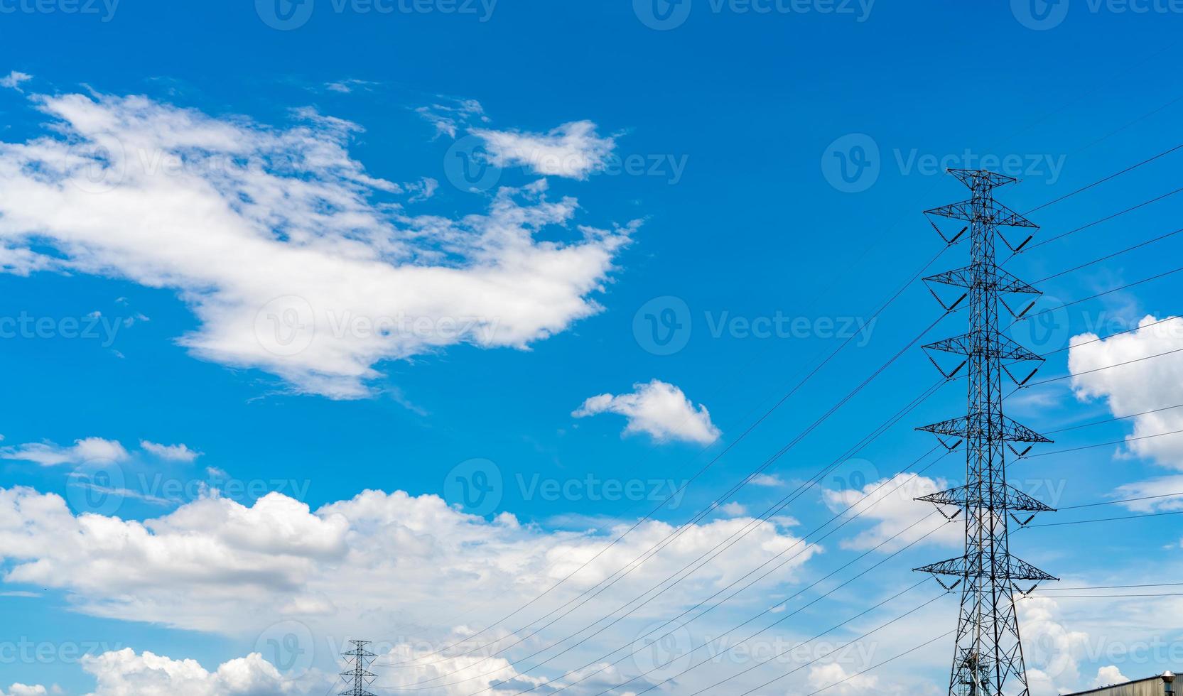 High voltage electric pylon and electrical wire against blue sky and white clouds. Electricity pylon. Power and energy concept. High voltage grid tower with wire cable. Transmission line on sunny day. photo