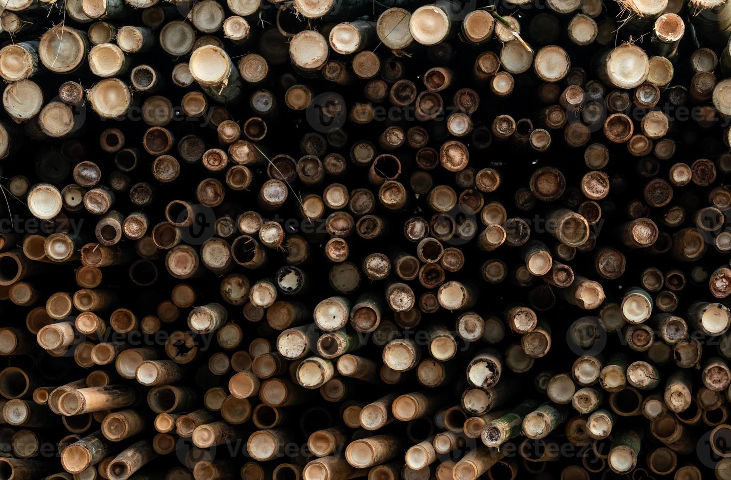 Pile of bamboo pole. Stack of round timber logs. Large batch of wooden logs for industrial scale or manufacturing. Warehouse of material for furniture factory. Art of bamboo abstract background. photo
