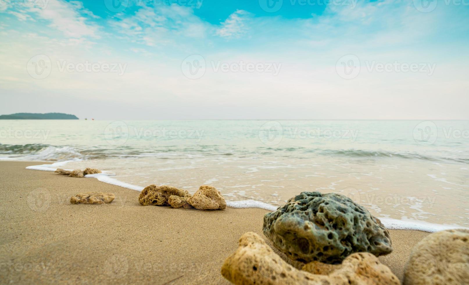 corales en la playa de arena junto al mar con cielo azul y nubes blancas. vacaciones de verano en el concepto de playa paraíso tropical. ondulación de salpicaduras de agua en la playa de arena. vibras de verano. coral que fueron arrastrados a tierra. foto