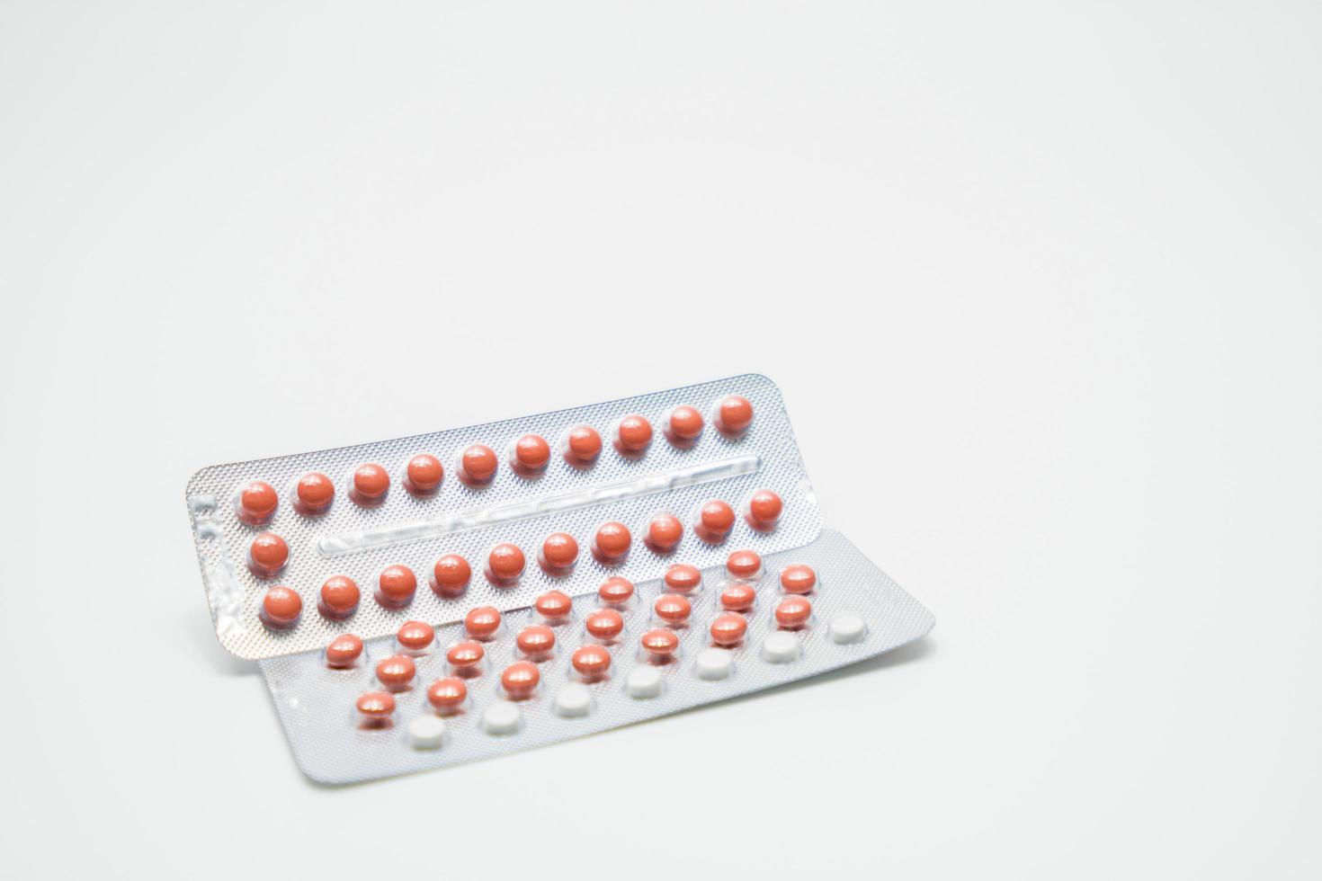Contraceptive pills in blister pack on white background. Birth control pills 21 and 28 tablets. Hormones tablet pills. Pharmacy drugstore background. Pharmaceutical product. Estrogen and progesterone. photo
