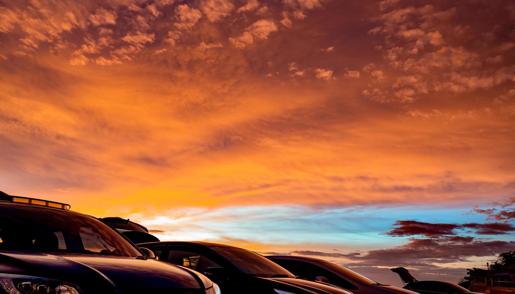 Car parked at outdoor car parking lot of campsite with beautiful sunset sky. Car drive for adventure road trip. Nature landscape. Road trip for summer vacation travel with friends at holidays park. photo