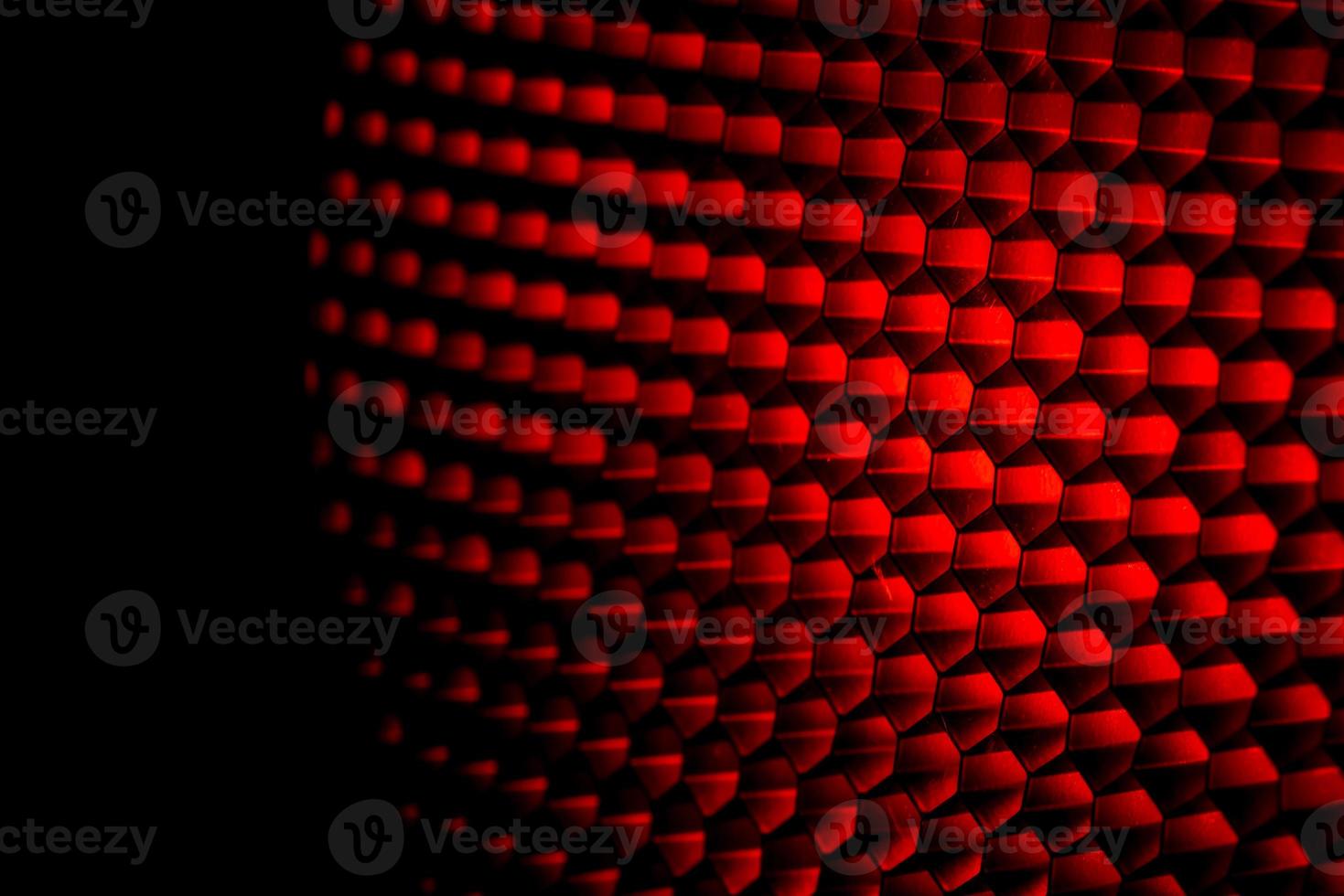 Closeup honeycomb grid texture with red light. Red and dark metal hexagon shaped pattern abstract background. Light modifier equipment. Metal honeycomb. Futuristic pattern. Honey grid cells network. photo