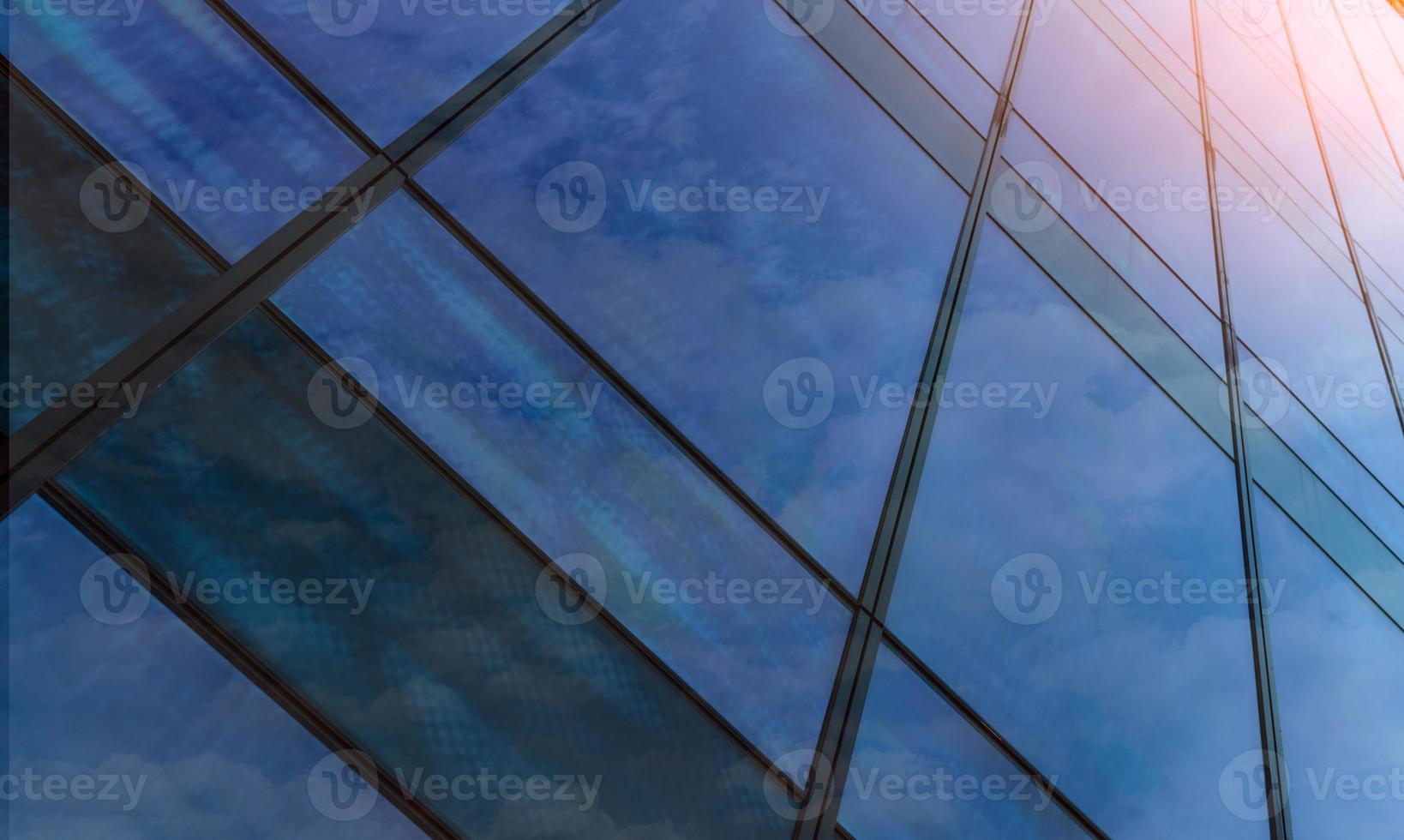 Perspective view of modern futuristic glass building abstract background. Exterior of office glass building architecture. Reflection in transparent glass of business building. Company glass window. photo