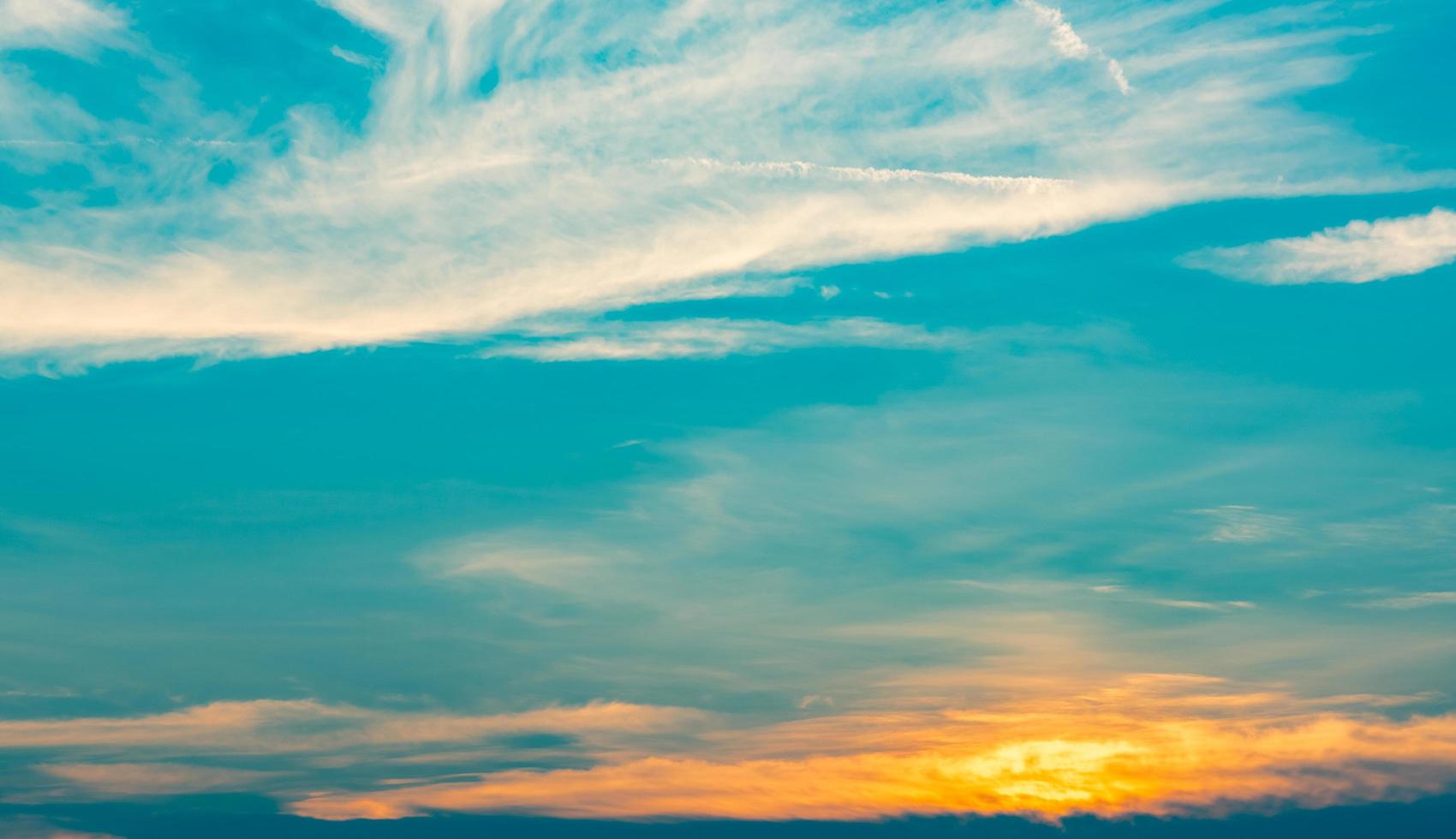 Beautiful blue and golden sky and clouds abstract background. Yellow-orange clouds on sunset sky. Warm weather background. Art picture of sky at sunset. Sunset and fluffy clouds for inspiration. photo