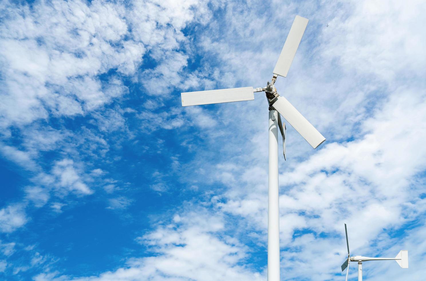 Wind turbine at wind farm on blue sky. Alternative and renewable energy concept. Sustainable electricity. Green energy concept. Small turbine. Clean energy industry. Eco friendly energy. Nature power. photo