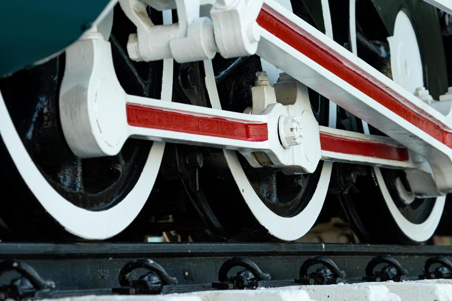 Closeup wheel of train. Green red and white train. Antique vintage train locomotive. Old steam engine locomotive. Black locomotive. Old transportation vehicle. photo