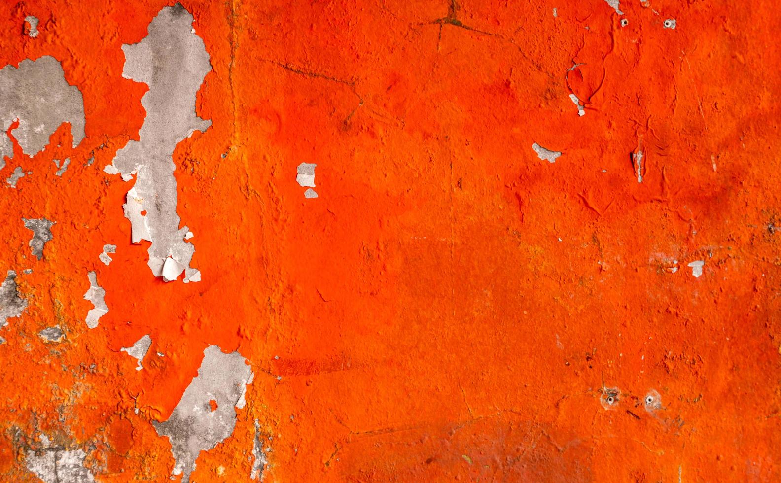 Orange color painted on concrete wall are peeling. Old and dirty wall texture background with space. photo