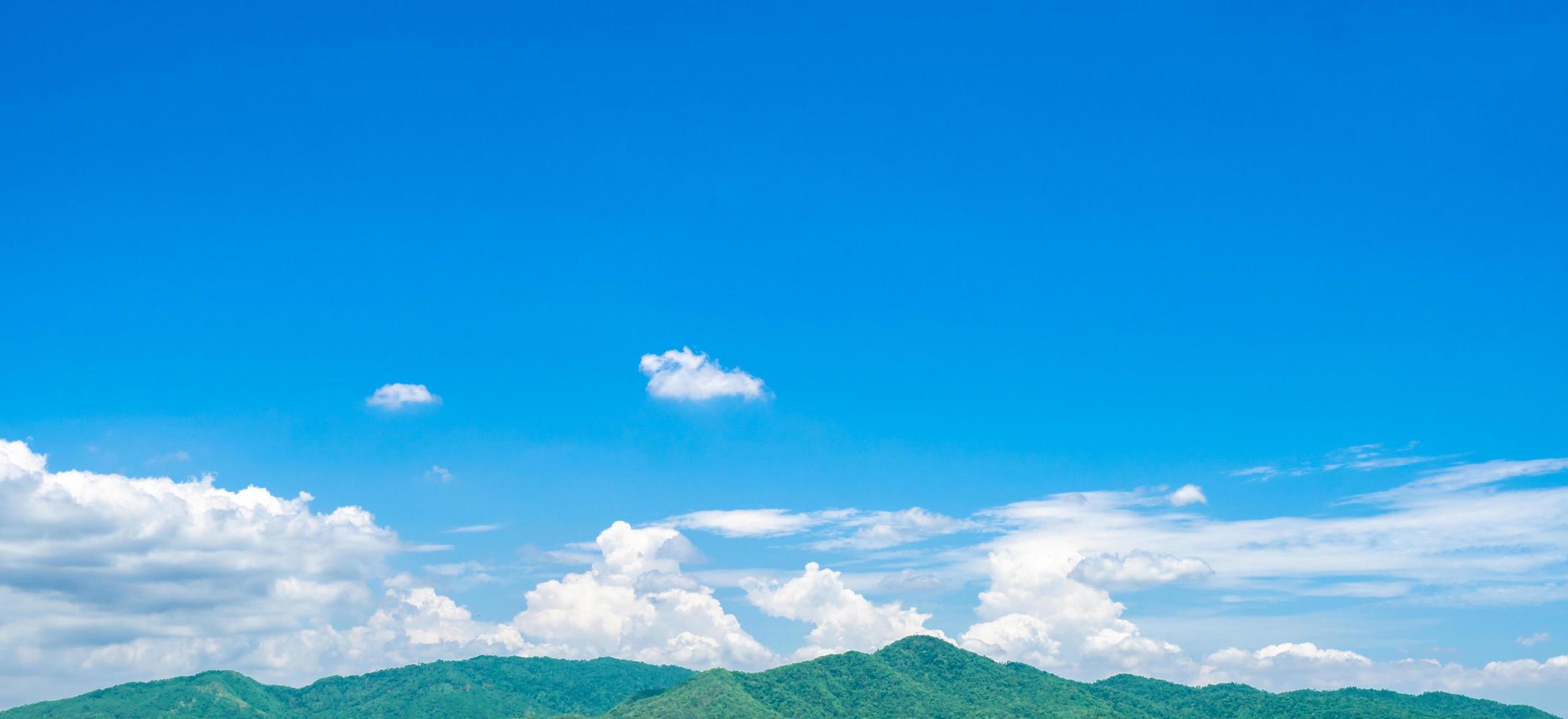 Blue sky and white cumulus clouds over green mountain. Beauty in nature. White fluffy clouds. Tropical nature. Sunny day. Heaven and tranquil scene. Summer weather. Love nature concept. Fresh air. photo