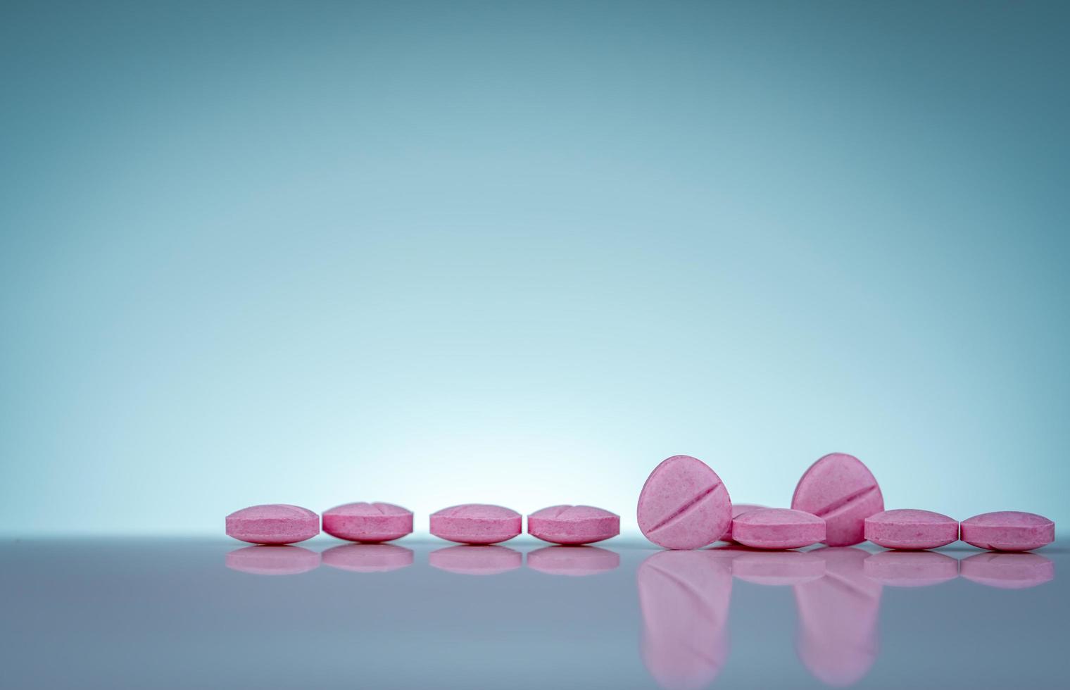 pastillas rosadas con sombra sobre fondo degradado. industria farmacéutica. productos de farmacia vitaminas y suplementos. uso de medicamentos en el hospital o farmacia. mercado minorista mundial de medicamentos. foto