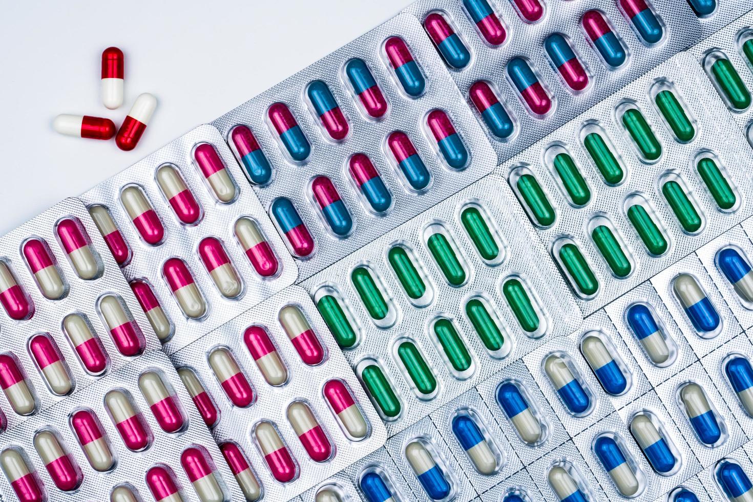 Top view of colorful capsule pills in blister pack arranged with beautiful pattern. Pharmaceutical packaging. Medicine for infections disease. Antibiotic drug use with reasonable. Drug resistance. photo