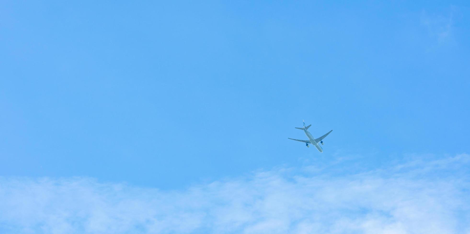 Airplane on blue sky and white clouds. Commercial airline flying on blue sky. Travel flight for vacation. Aviation transport. photo