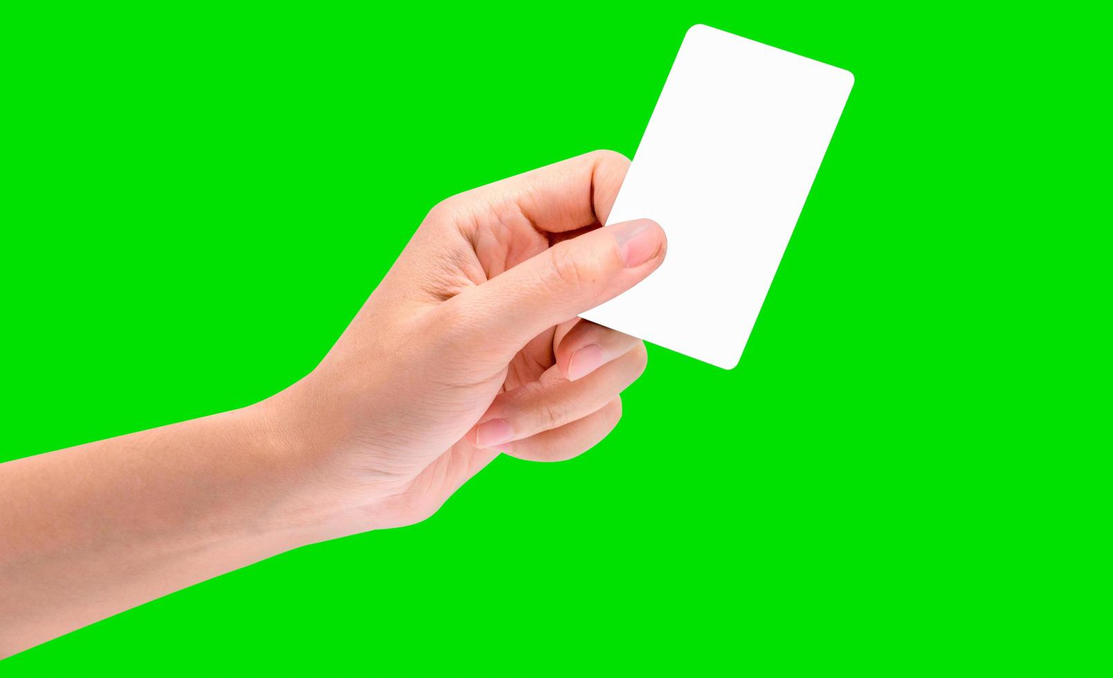 Hand hold business card, credit card or blank paper isolated on green background with clipping path. photo