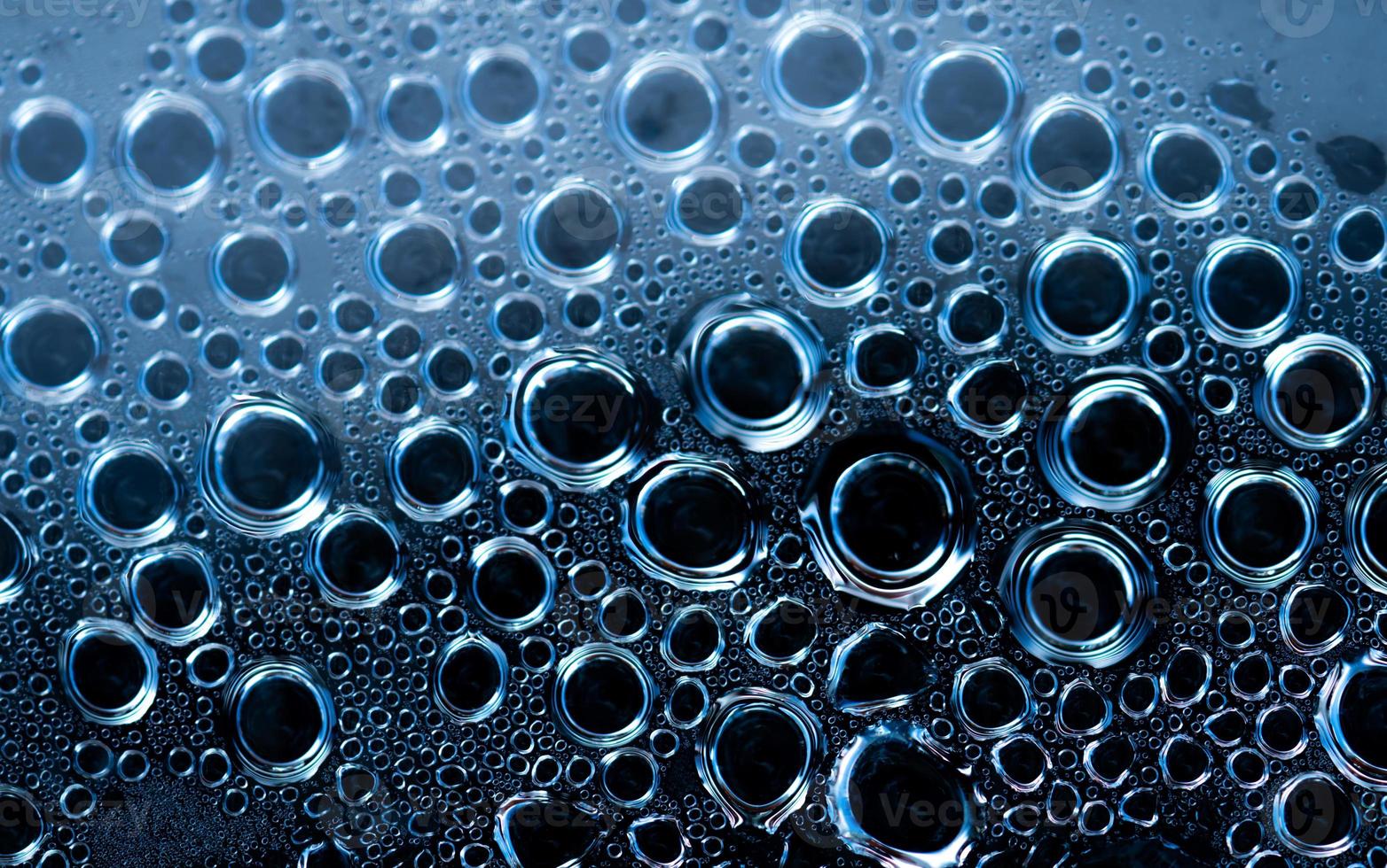 Macro shot detail of water drops with unique pattern. Water drops texture background. Round shape of droplet on dark background. Different size of water drops abstract background. photo