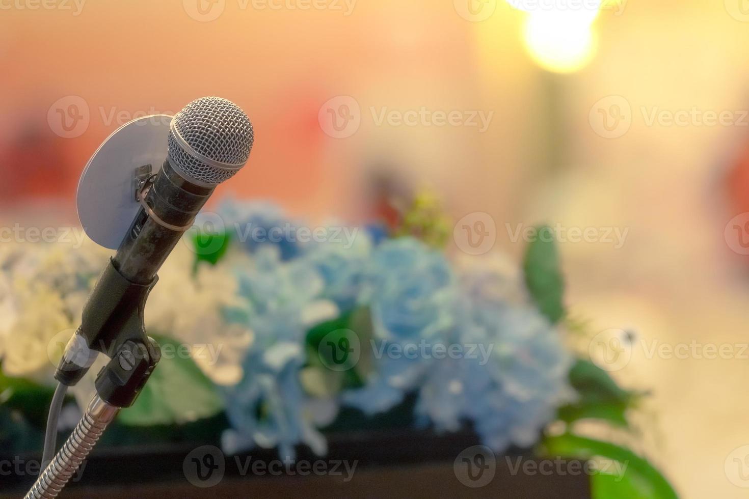 Microphone on stand at podium stage for public speaking or speech in conference hall. Mic for speaker on stage of event. Meeting and presentation in seminar room. Microphone for talking to audience. photo