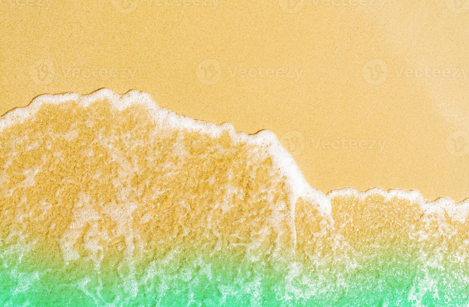 Golden sand at seaside. Sea water wave on the beach. Sand and sea water texture background.Summer vacation on tropical paradise beach concept. Ripple of water splash on sandy beach. Calm and tranquil. photo