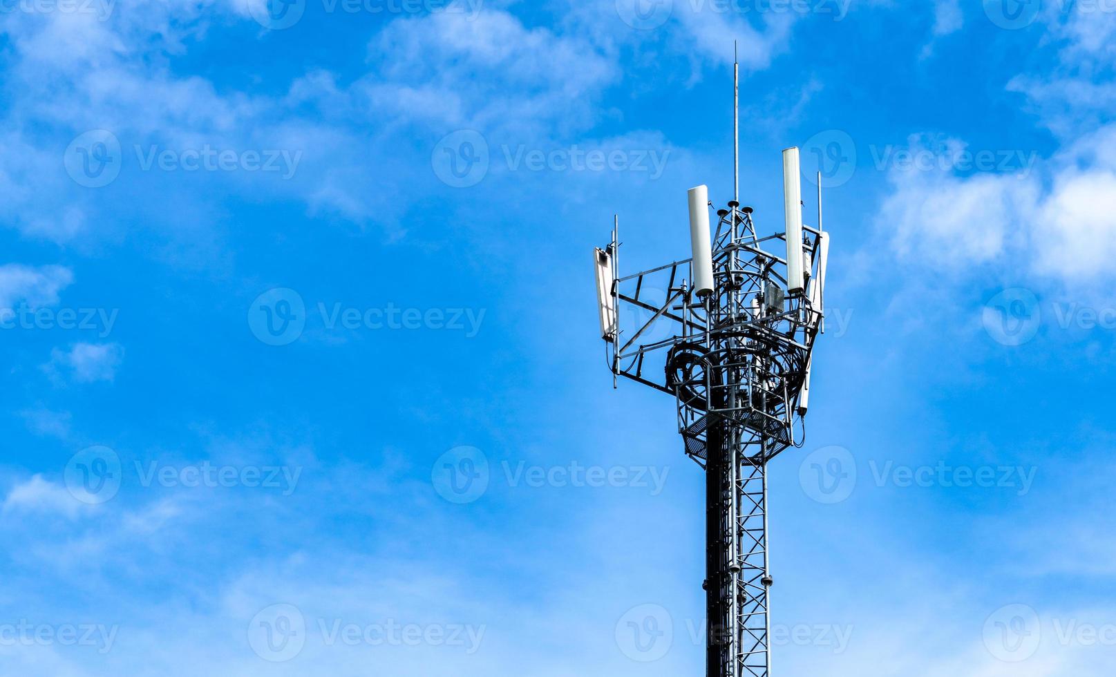 Telecommunication tower with blue sky and white clouds background. Antenna on blue sky. Radio and satellite pole. Communication technology. Telecommunication industry. Mobile or telecom 4g network. photo