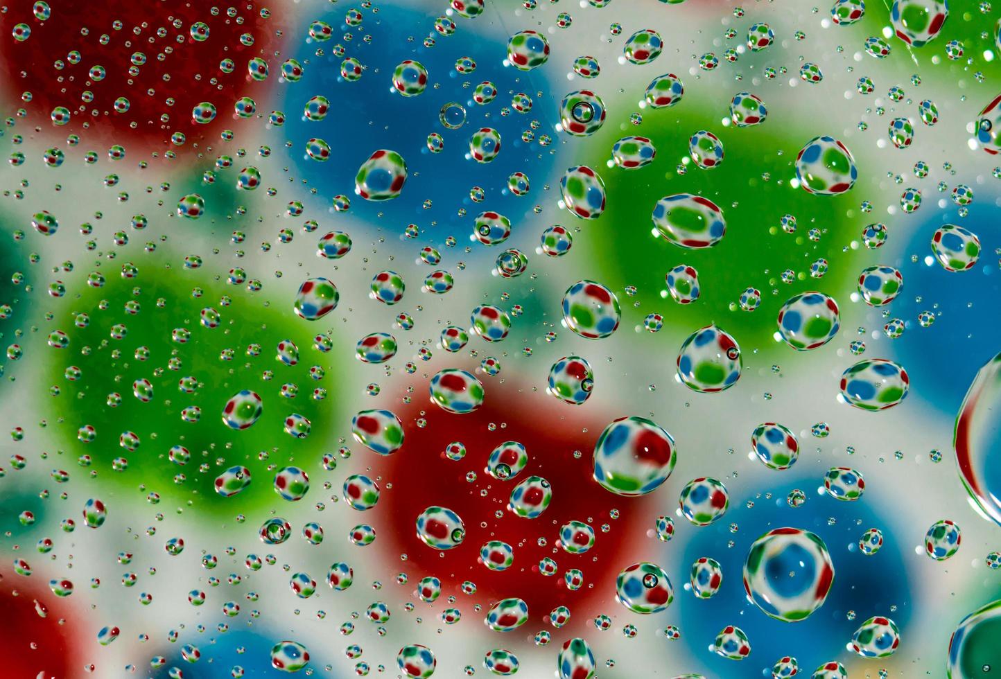 Colorful blurred background with water drops on transparent glass and reflection. photo