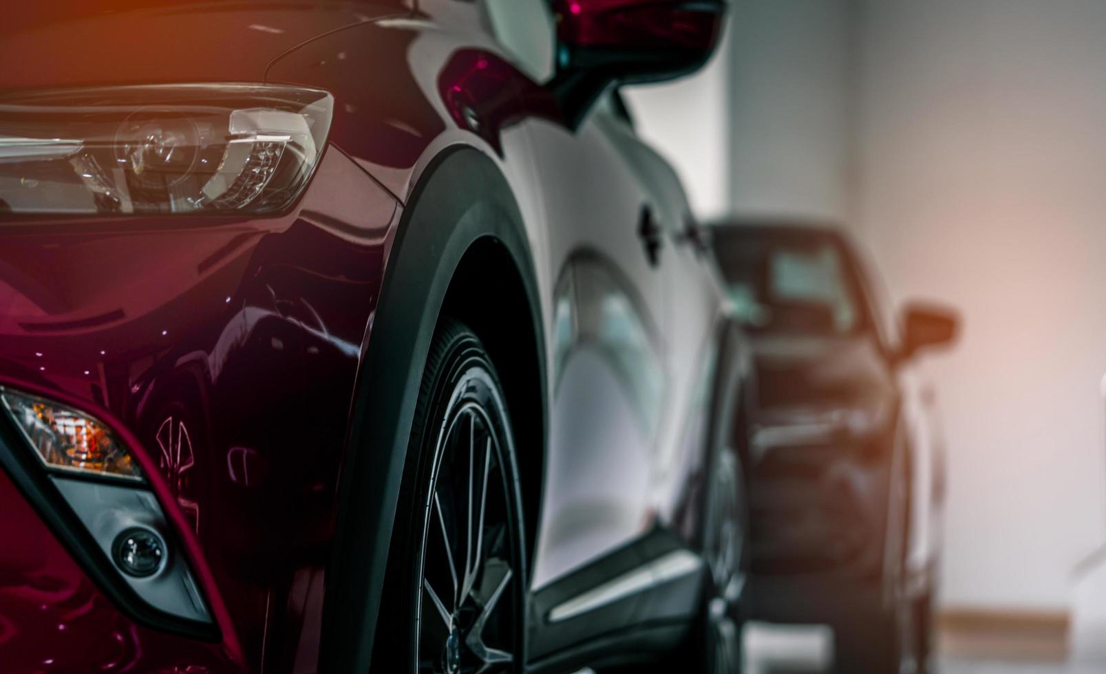 Coche compacto rojo nuevo de lujo estacionado en una moderna sala de exposición a la venta. oficina del concesionario de automóviles. tienda minorista de autos. tecnología de automóviles eléctricos y concepto de negocio foto