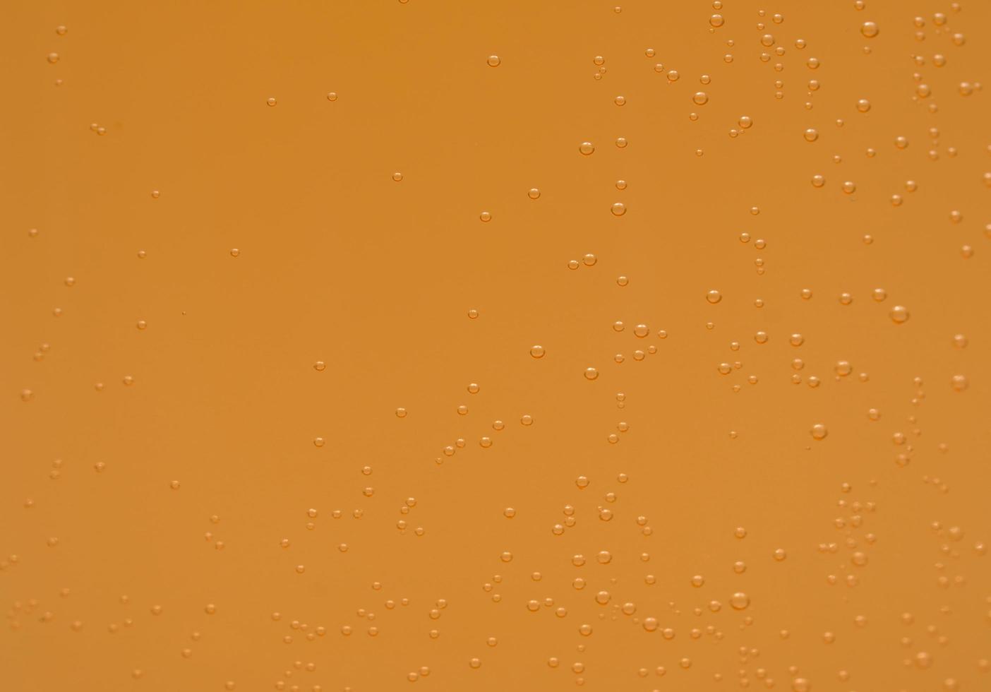 Macro shot of orange effervescent bubbles of calcium and vitamin C effervescent tablets in transparent glass photo