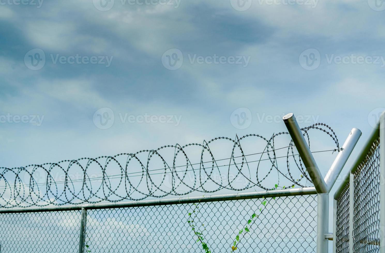 Prison security fence. Barbed wire security fence. Razor wire jail fence. Barrier border. Boundary security wall. Prison for arrest criminals or terrorists. Private area. Military zone concept. photo