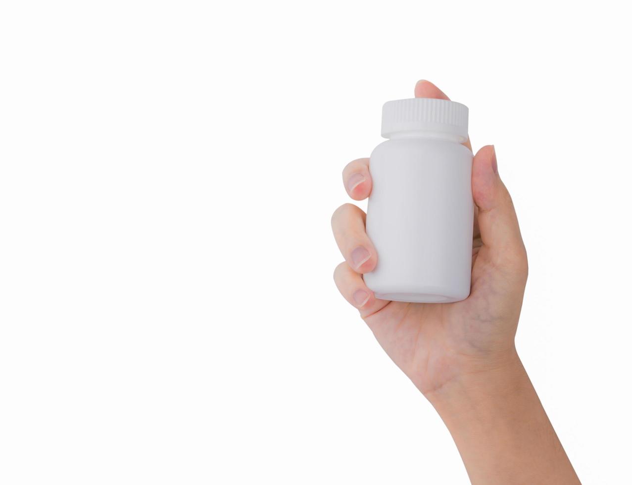 mano de mujer sosteniendo una botella de píldoras recetadas con una etiqueta en blanco aislada en fondo blanco con espacio para copiar texto. foto