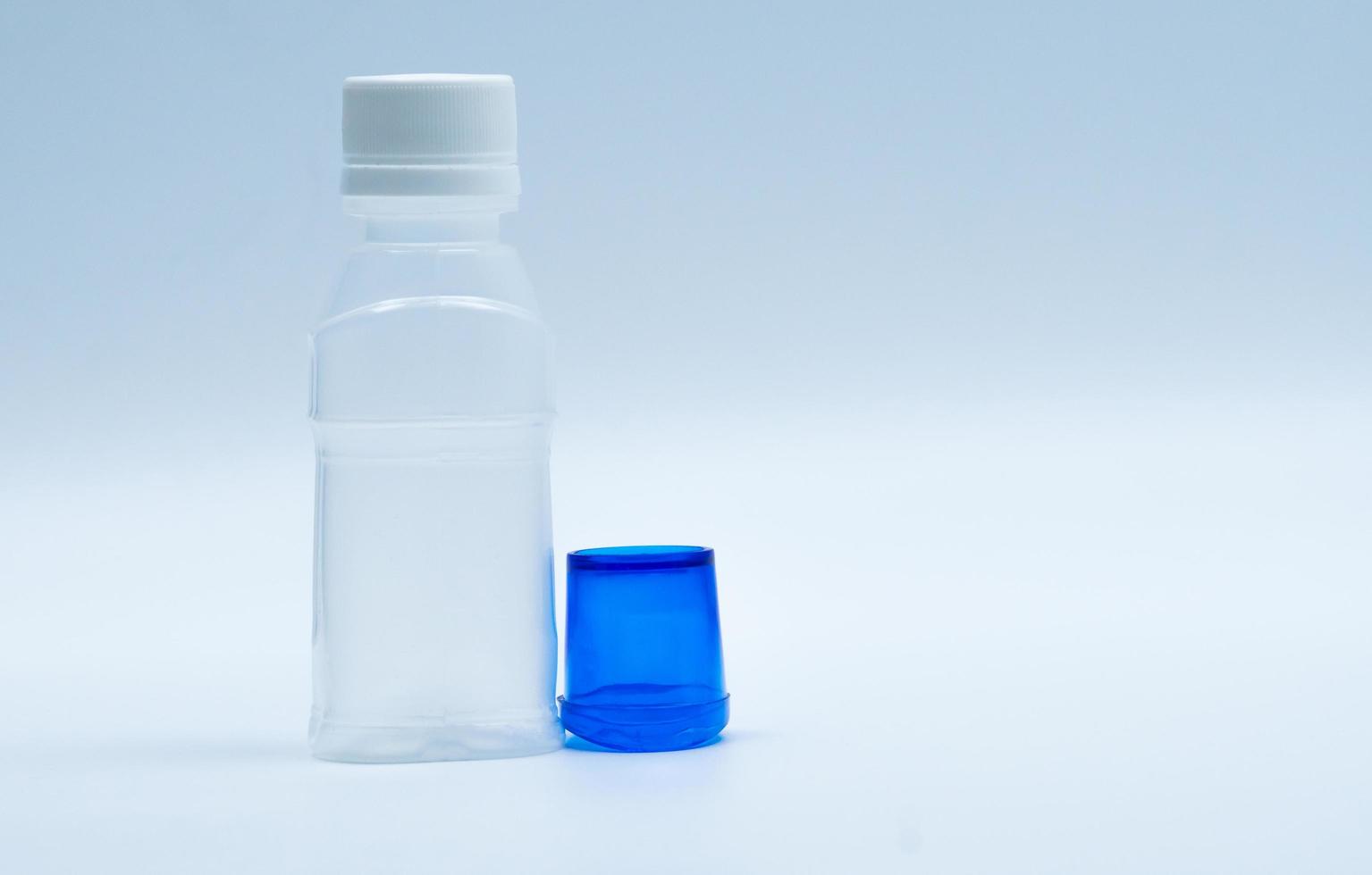 loción ocular estéril en botella de plástico blanco con baño de ojos azul y espacio de copia y etiqueta en blanco. lavado de ojos después de la contaminación del contacto con el medio ambiente o después de nadar en una piscina contaminada con cloro. foto