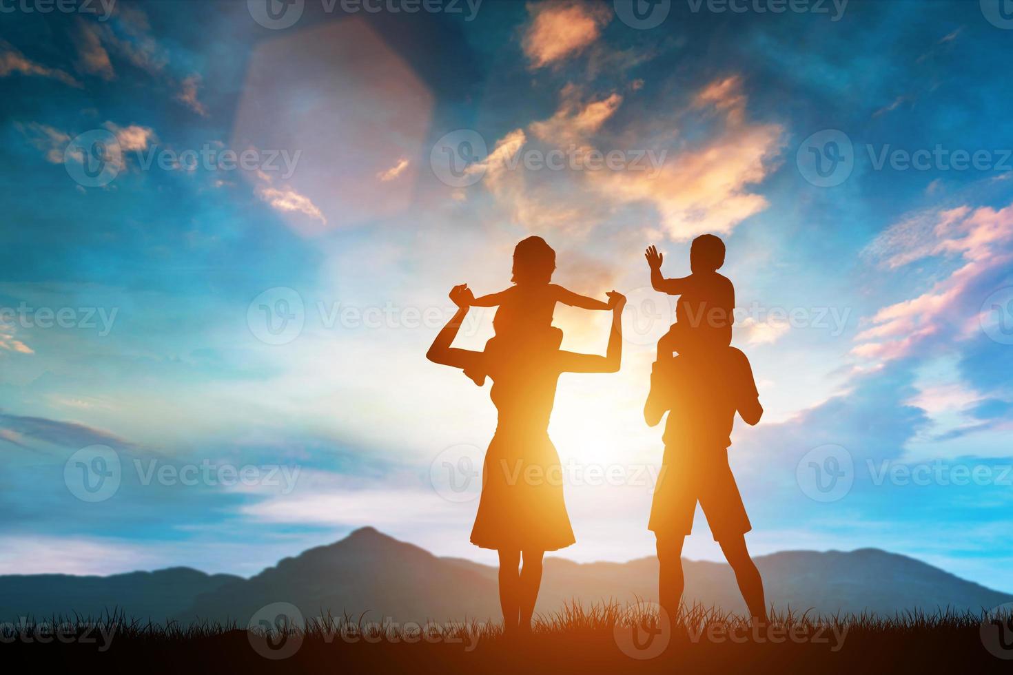 Parents and two children sitting on their shoulders. photo