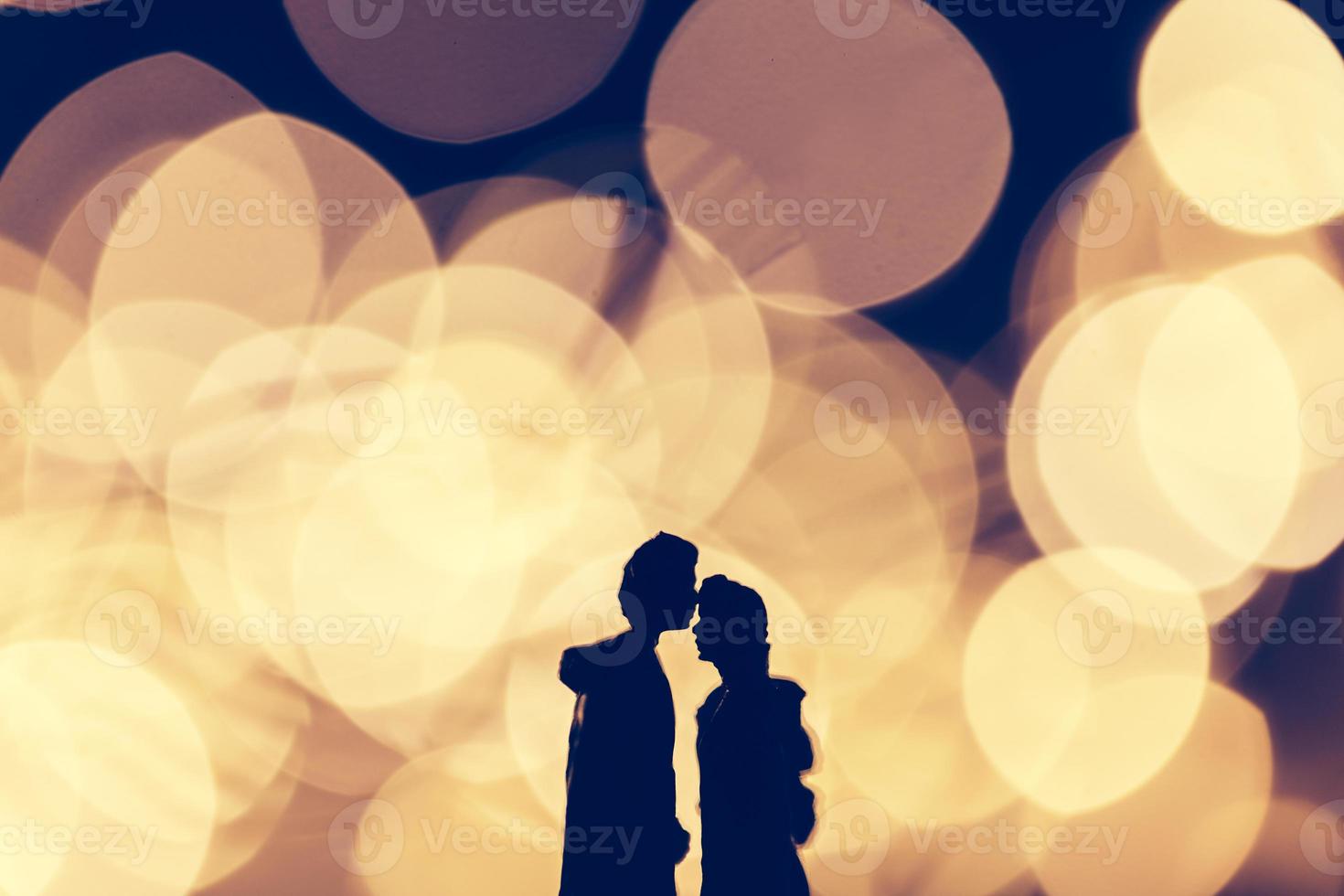 Romantic couple kissing on illuminated background. photo