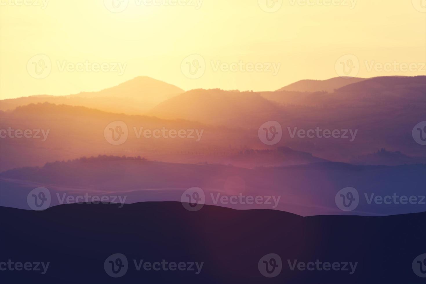Misty fields and rural hills during the sunset. photo