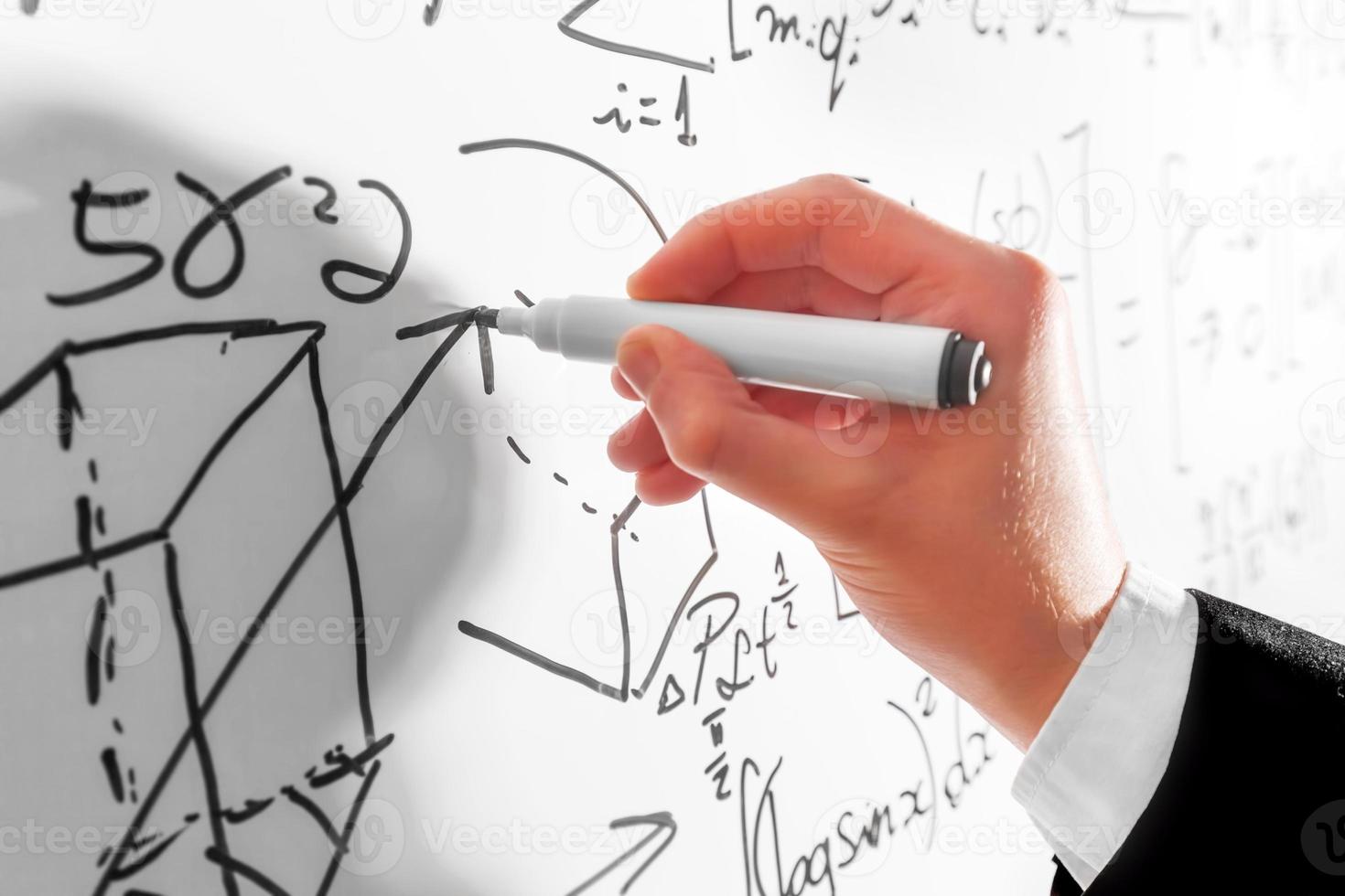 Man writing complex math formulas on whiteboard. Mathematics and science photo