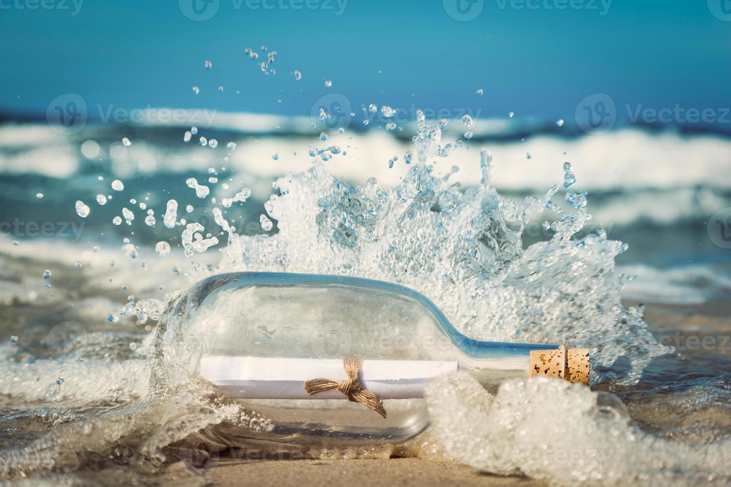 Message in the bottle coming with wave from ocean photo