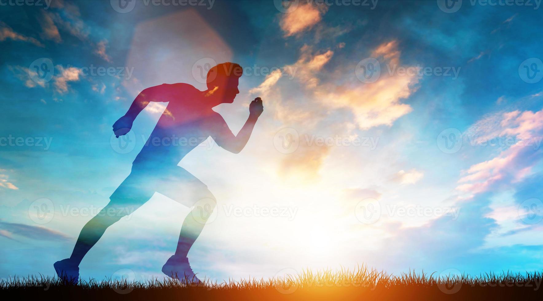 Muscular man running fast on the meadow in a sunset. photo