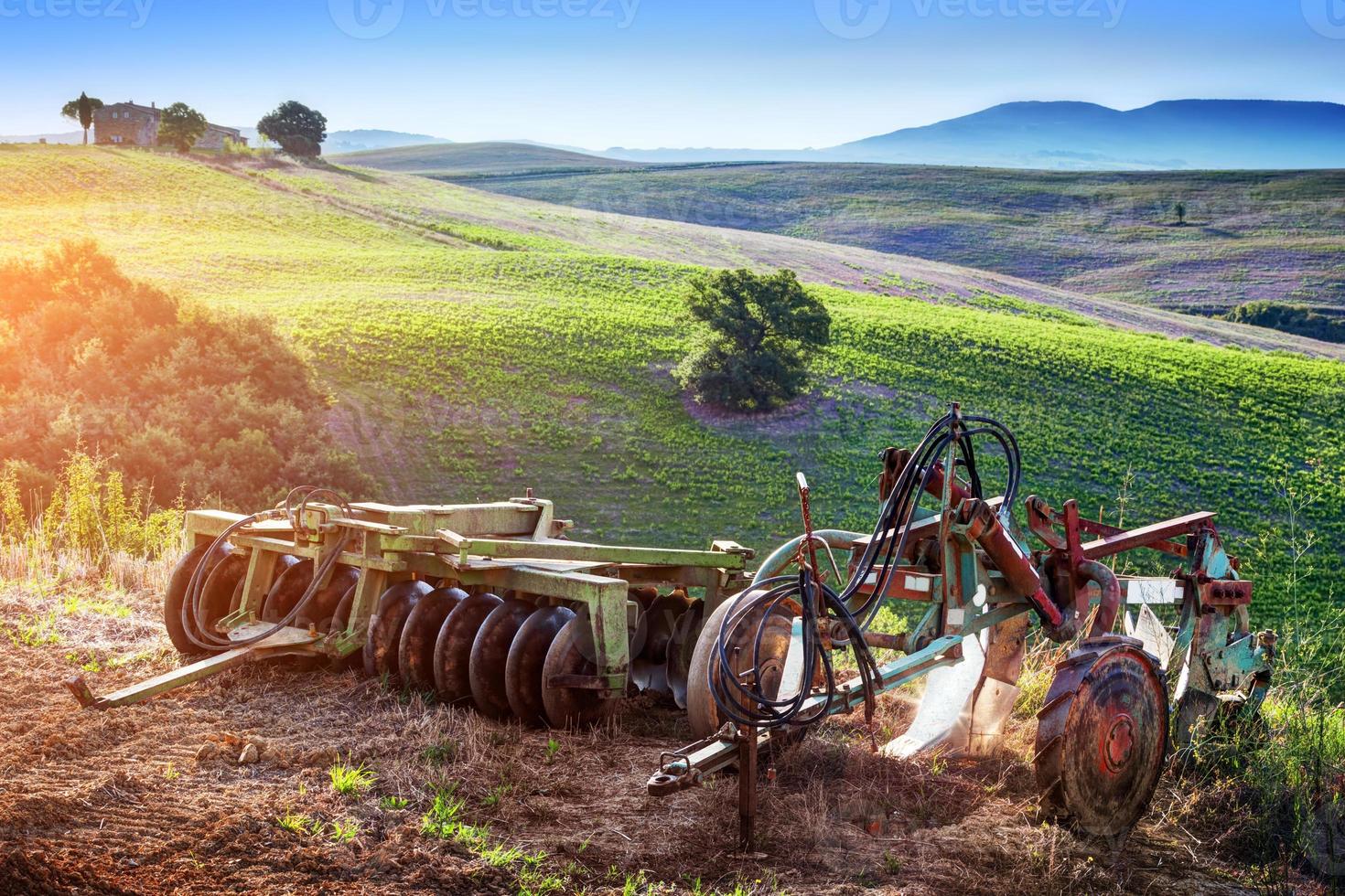 Tuscany landscape at sunrise. Retro agriculture machines. Italy photo