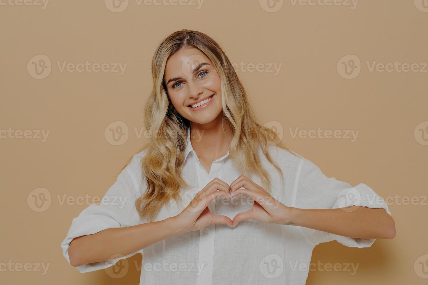mujer rubia haciendo forma de corazón con sus manos foto