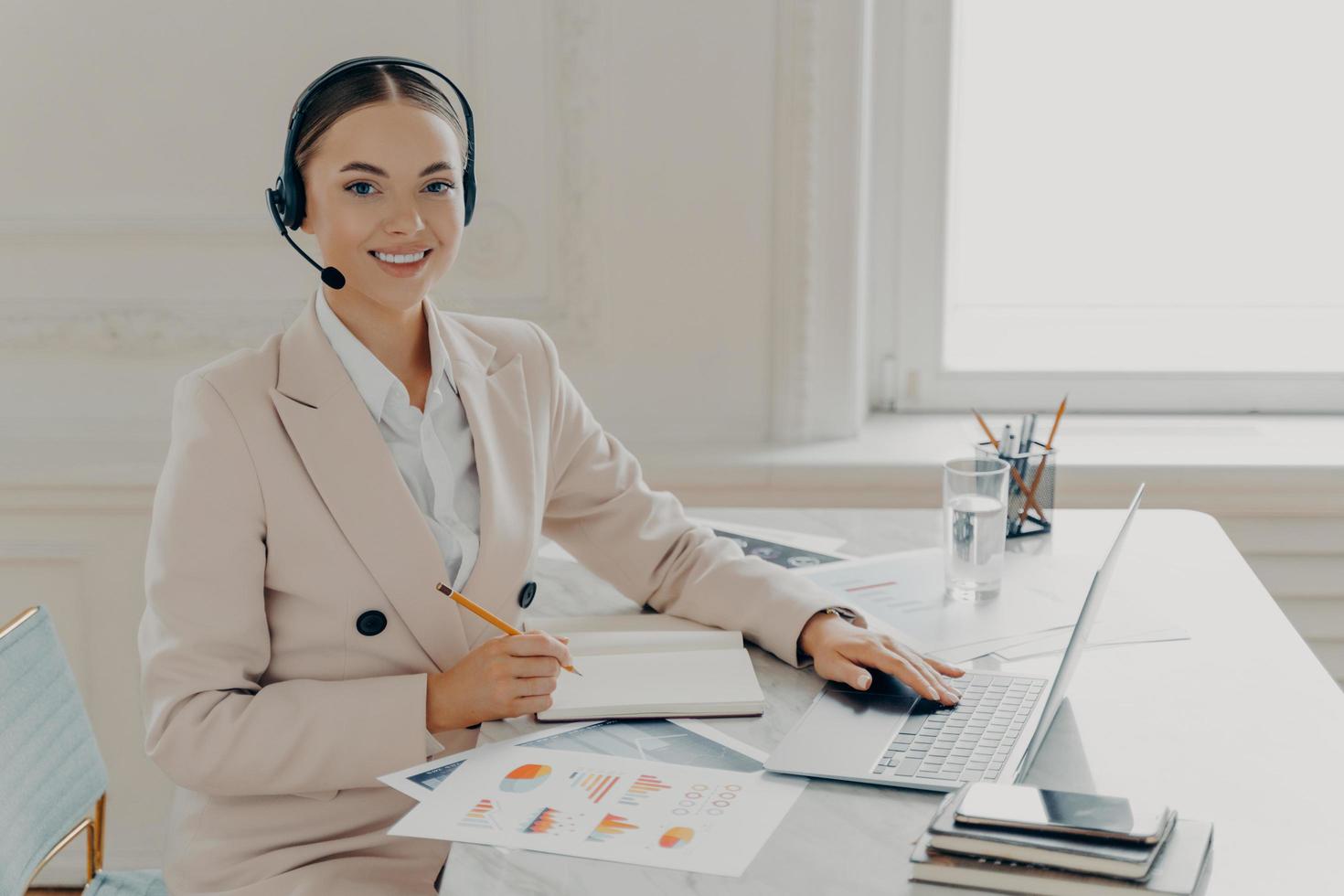 Smiling female economist having web conference in office photo