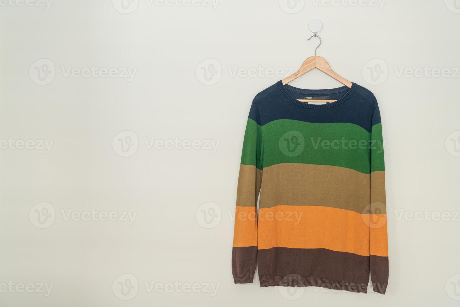 colorful sweater hanging with wood hanger photo