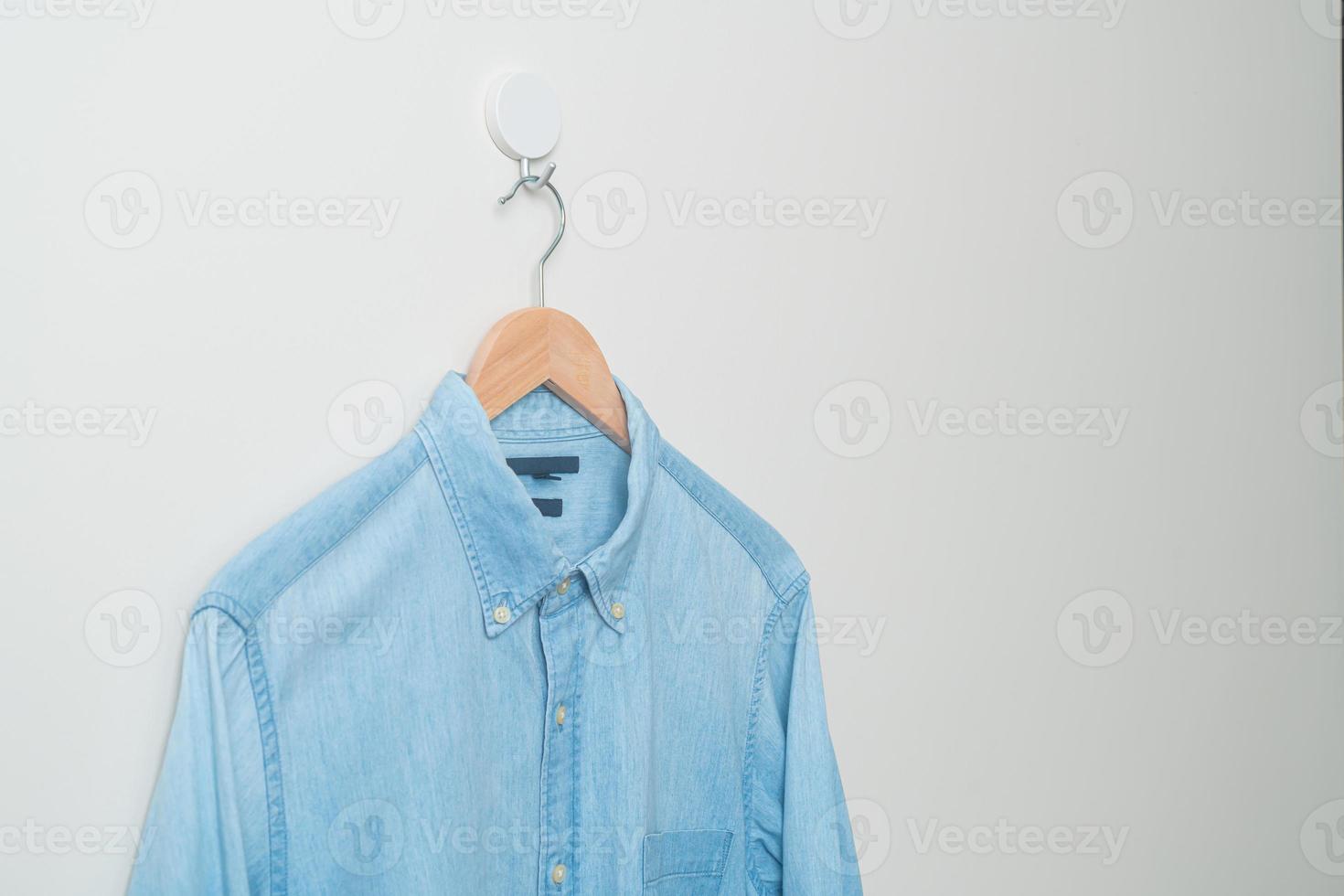 camisa colgante con colgador de madera en la pared foto