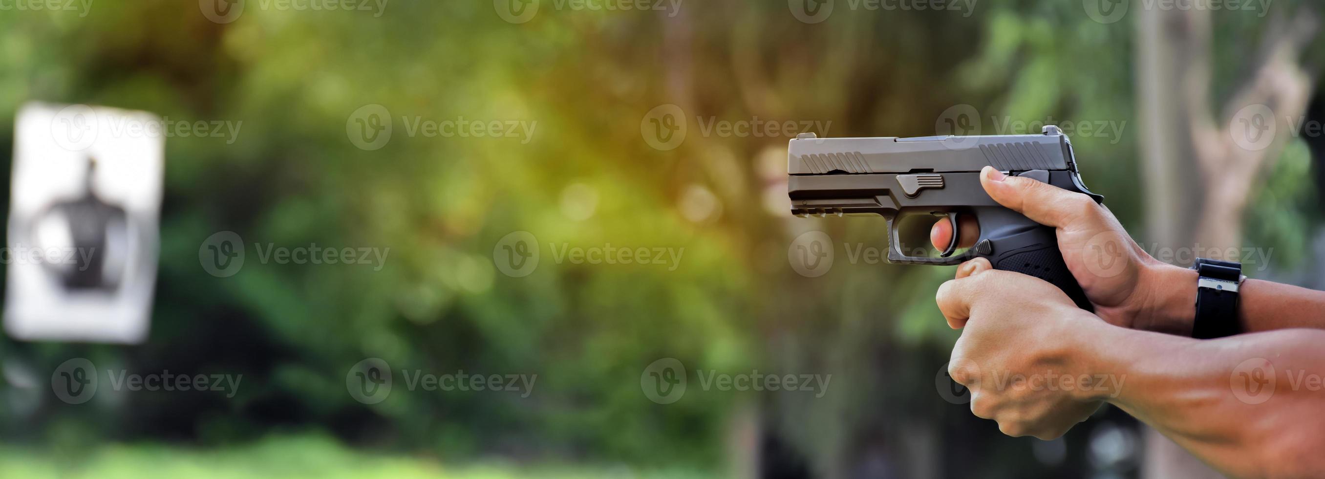 Pistola automática de 9 mm sujeta en la mano derecha del tirador, concepto de seguridad, robo, gángster, guardaespaldas en todo el mundo. enfoque selectivo en pistola. foto