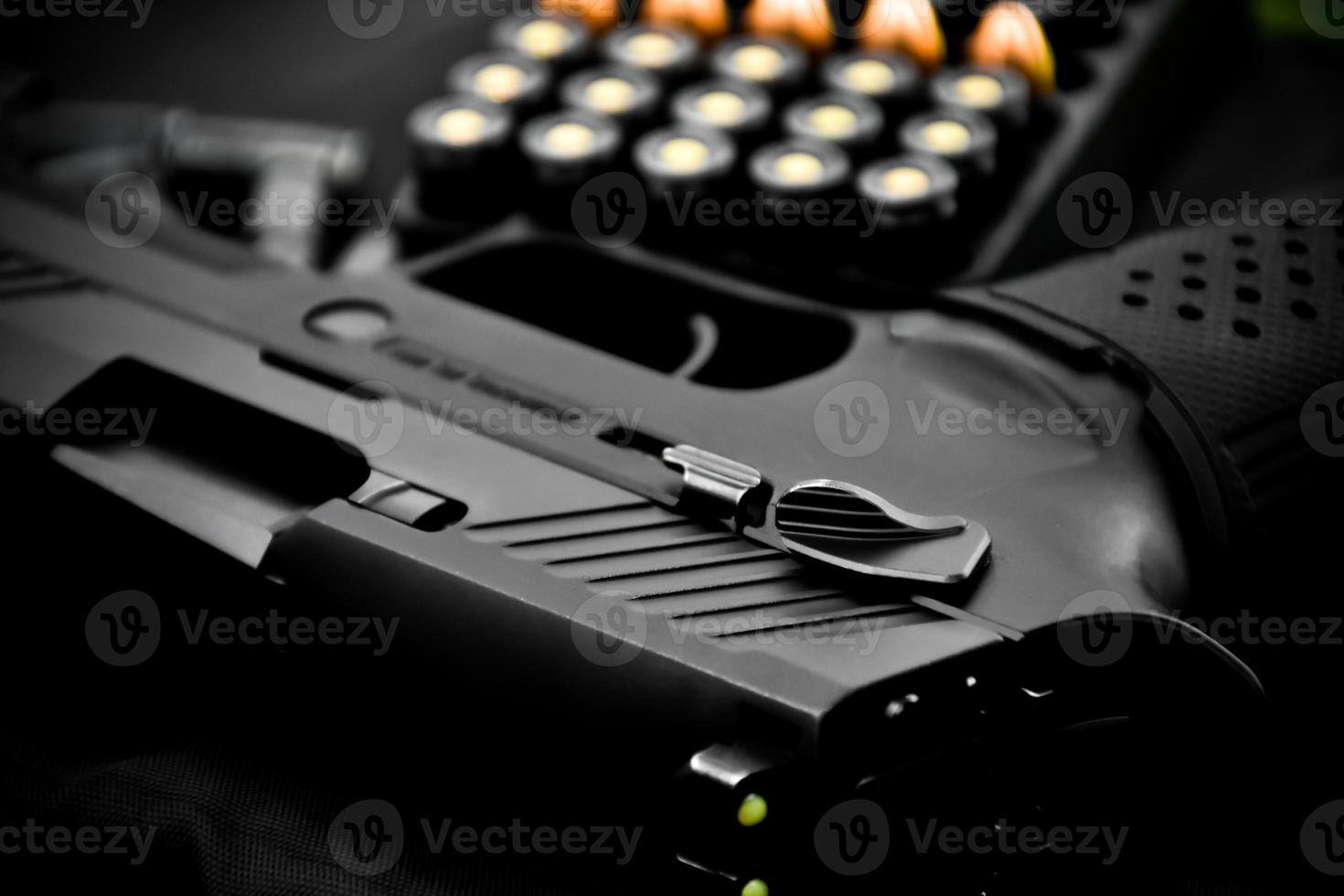 9mm automatic pistol and bullets on wooden floor, soft and selective focus. photo