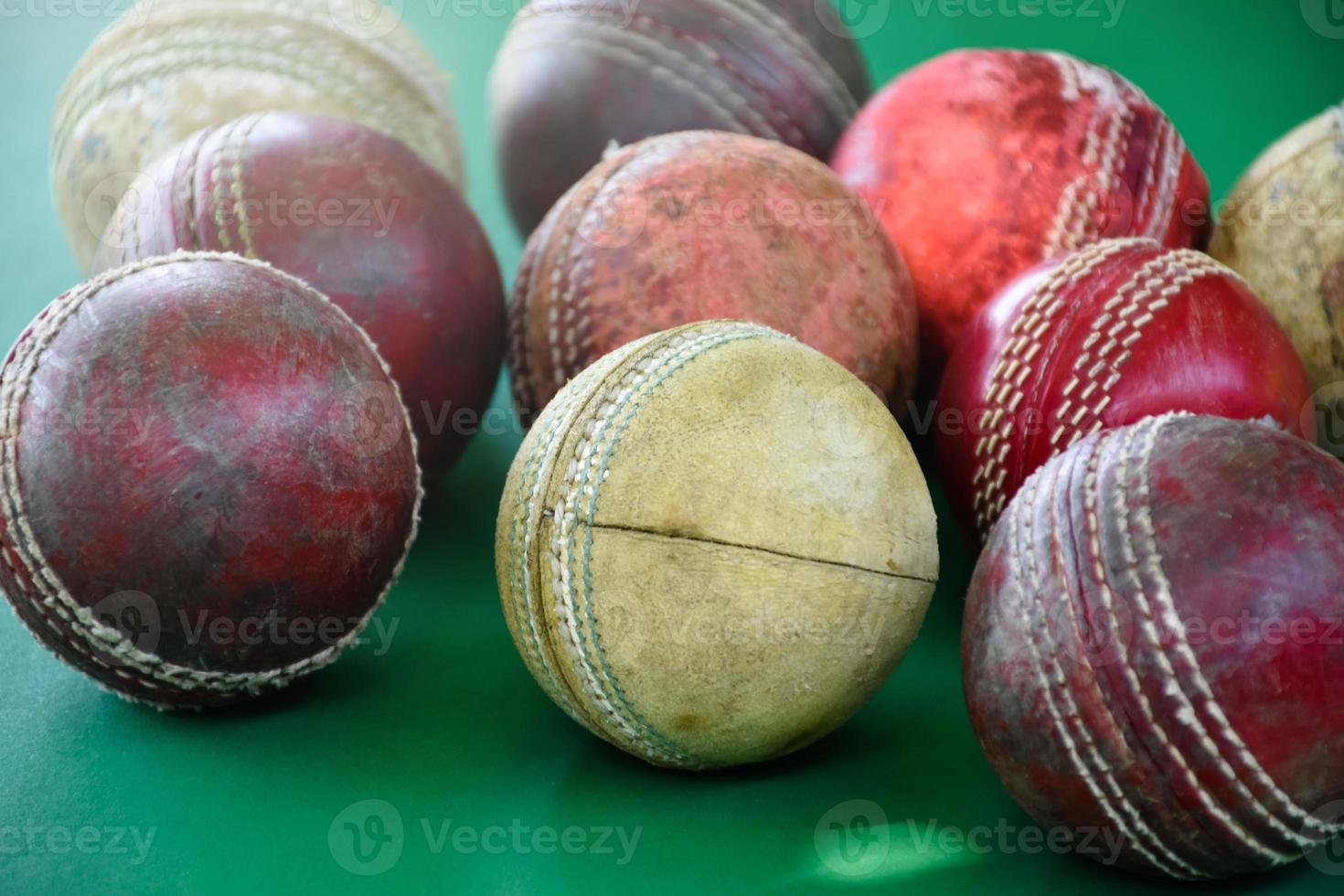 Primer plano de pelotas de cricket de cuero viejas y usadas en suelo verde, enfoque suave y selectivo. concepto para los amantes del críquet de todo el mundo. foto