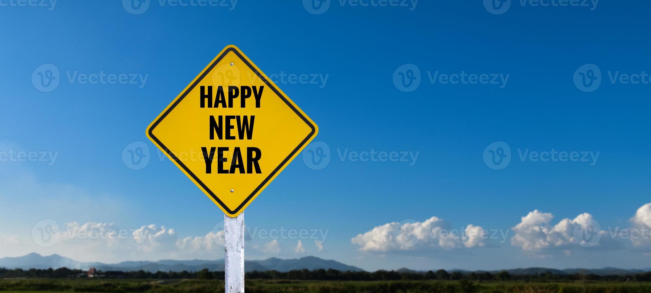 Yellow label traffic sign on white pole which has texts 'Happy New Year' on it, concept for informing happy new year to the drivers on the way. photo