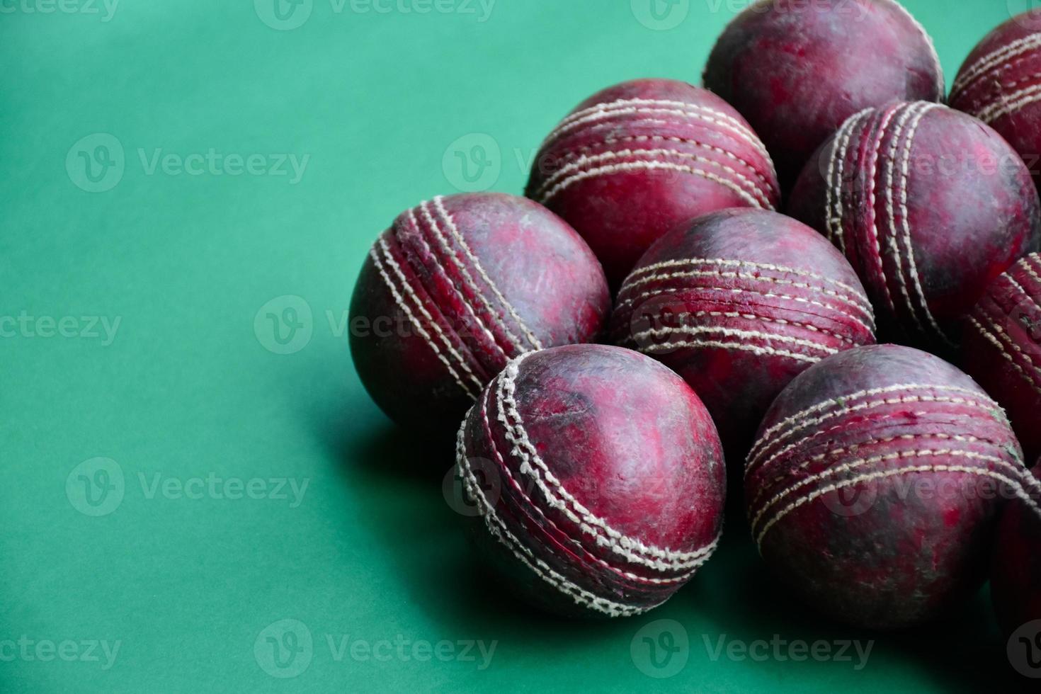 Old training cricket sport equipments on dark floor, leather ball, wickets, helmet and wooden bat, soft and selective focus, traditional cricket sport lovers around the world concept. photo