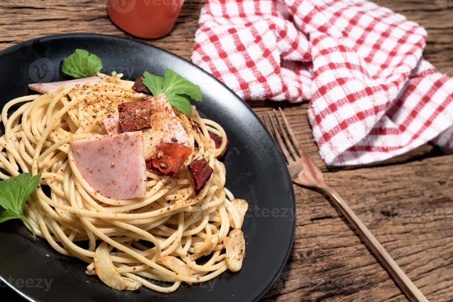 Pasta in black plate on wood background Italian food. photo