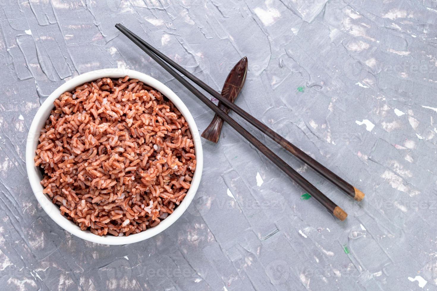 arroz rojo en un recipiente aislado sobre fondo gris. comida asiática cocinada. foto