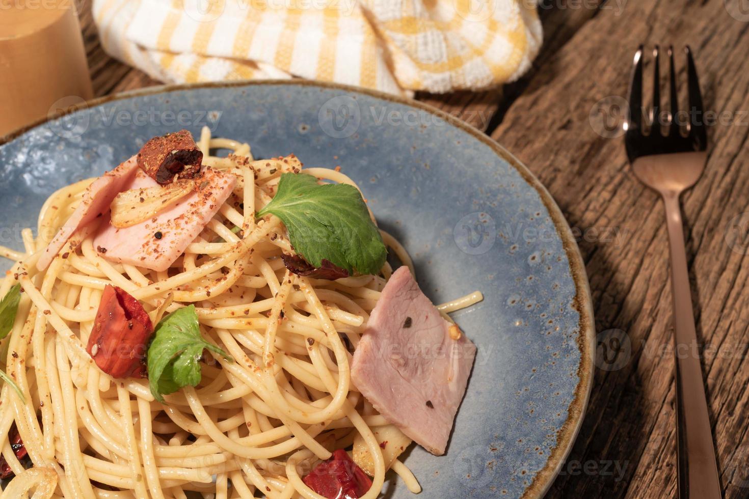 pasta en plato negro sobre fondo de madera comida italiana. foto