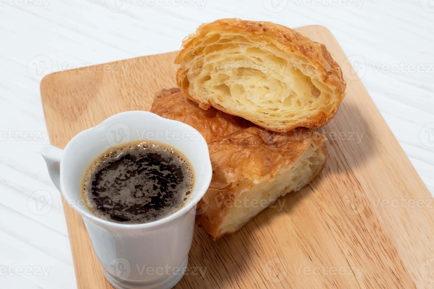 desayuno comida café y croissant en mesa de madera blanca. foto