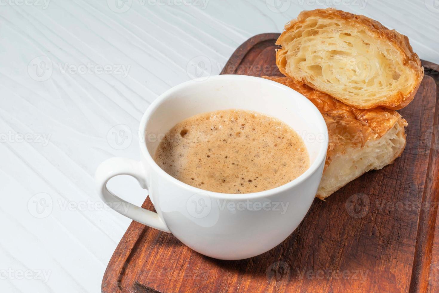 desayuno comida café y croissant en mesa de madera blanca. foto